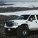 A late model Ford Excursion super truck with 6 doors in a snowy mountain landscape